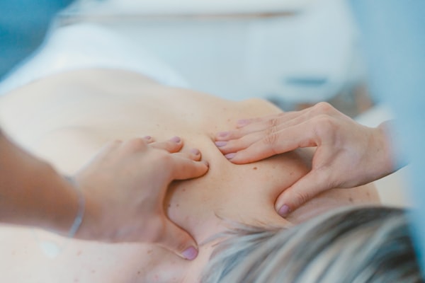 Hands assessing a patient's upper back